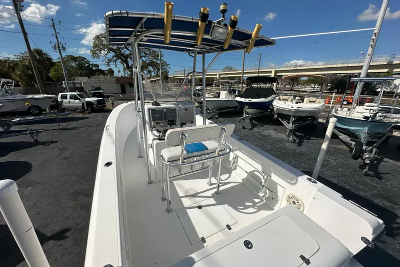 Slide: The Image of 1998 Bluewater 2150 boat with T-top and rod holders, parked in a marina under clear skies. - 12
