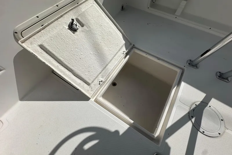 Slide: The Image of Open storage compartment on 1998 Bluewater 2150 boat deck, showing interior space. - 13
