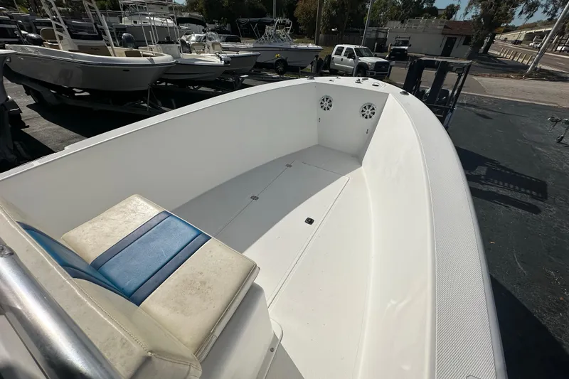 Slide: The Image of 1998 Bluewater 2150 boat interior with white seating and deck, parked among other boats. - 5