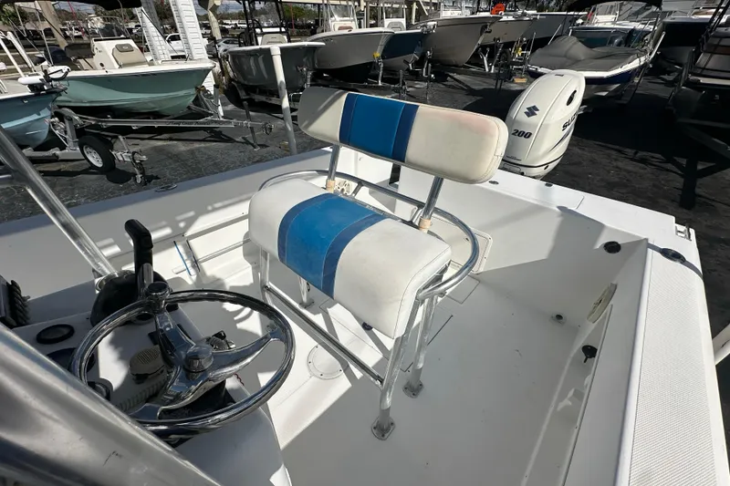 Slide: The Image of 1998 Bluewater 2150 boat interior with steering wheel and seating, surrounded by other boats. - 9
