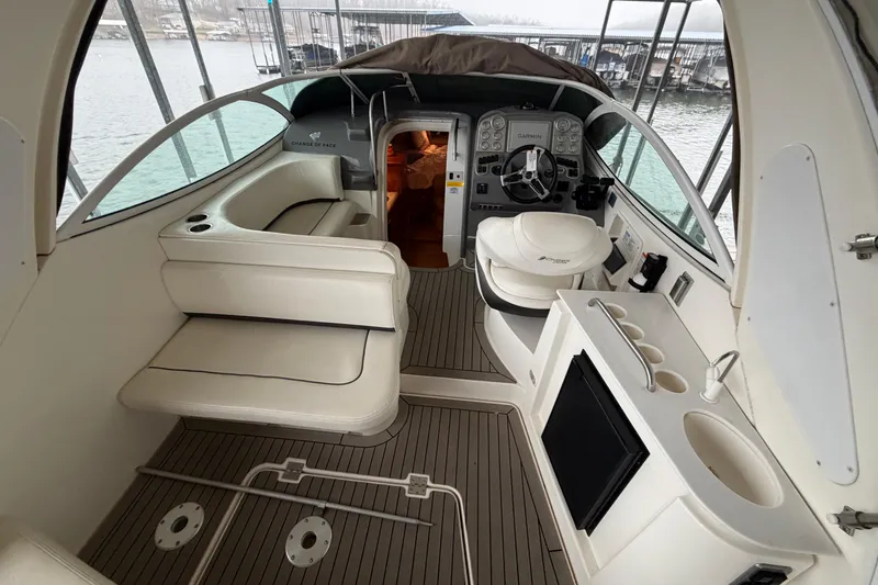 Slide: The Image of 2006 Cruisers Yachts 300 Express interior with helm, seating, and kitchenette on a docked boat. - 19