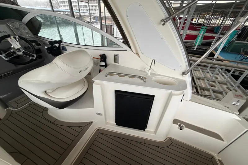 Slide: The Image of 2006 Cruisers Yachts 300 Express cockpit with helm, seating, and sink area. - 20