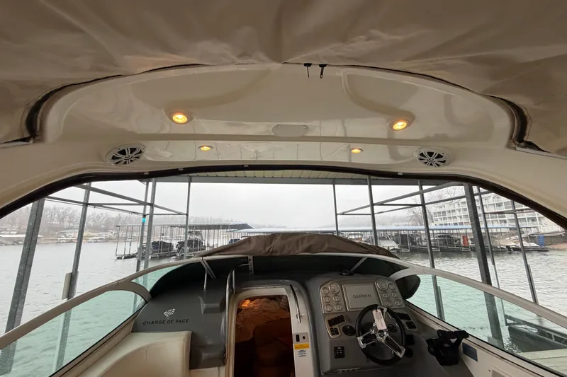 Slide: The Image of 2006 Cruisers Yachts 300 Express interior view at marina, showcasing helm and seating area. - 22
