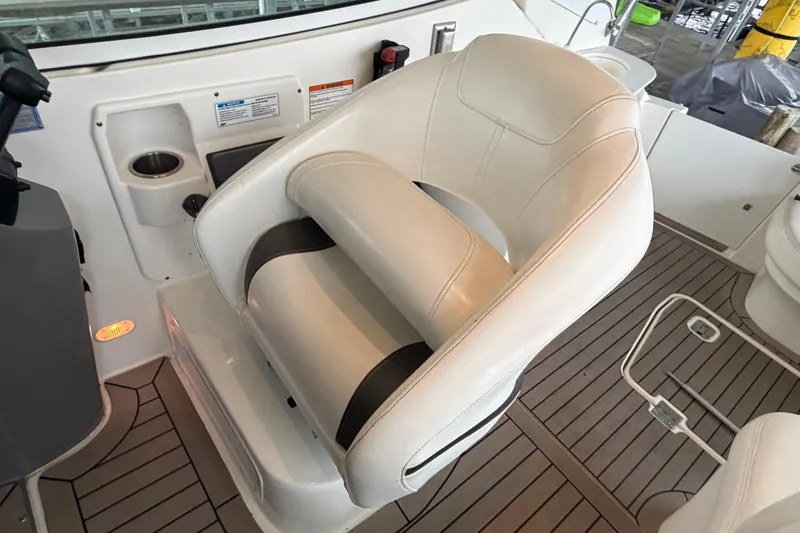 Slide: The Image of Captain's chair on 2006 Cruisers Yachts 300 Express, featuring white upholstery and teak flooring. - 27