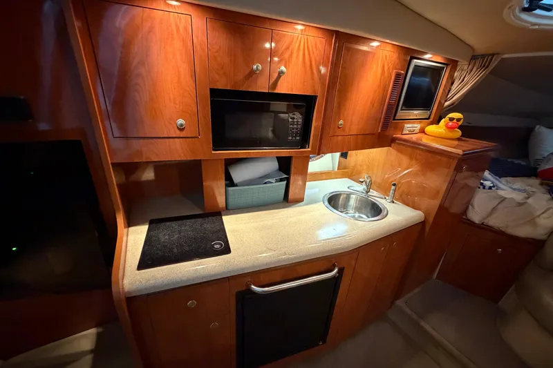 Slide: The Image of 2006 Cruisers Yachts 300 Express interior kitchen with wood cabinets and modern amenities. - 30