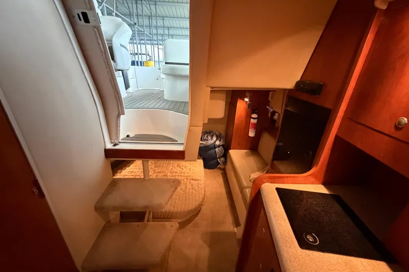 Slide: The Image of Interior of 2006 Cruisers Yachts 300 Express, featuring stairs and compact kitchen area. - 31