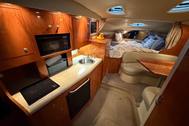Slide: The Image of 2006 Cruisers Yachts 300 Express interior with kitchenette, seating, and cozy sleeping area. - 34