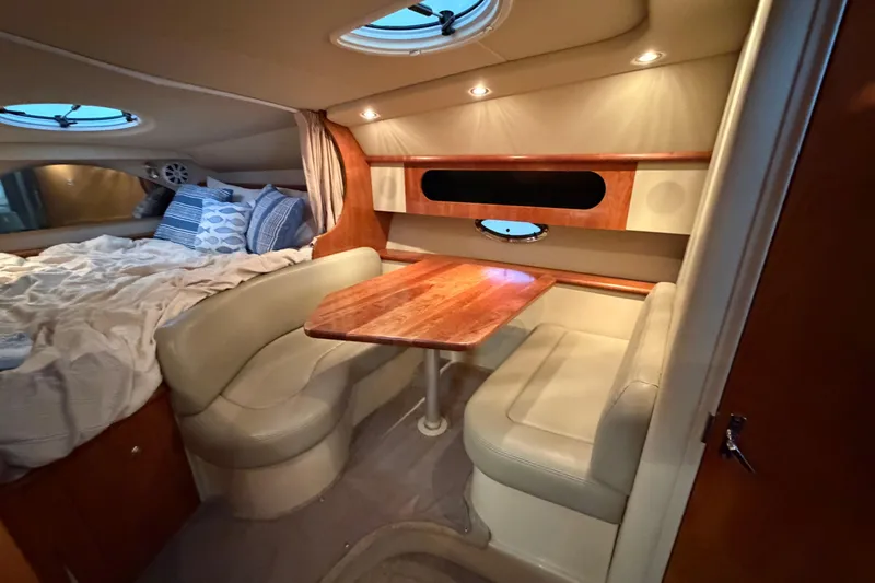 Slide: The Image of 2006 Cruisers Yachts 300 Express cabin with cozy seating and wooden table. - 35