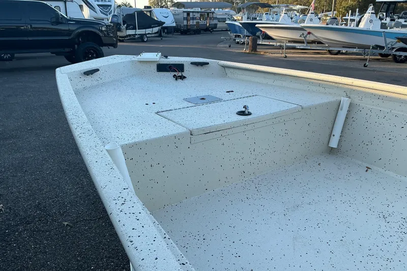 Slide: The Image of 2013 Xpress XP18CC boat interior, speckled white finish, parked among other boats. - 4