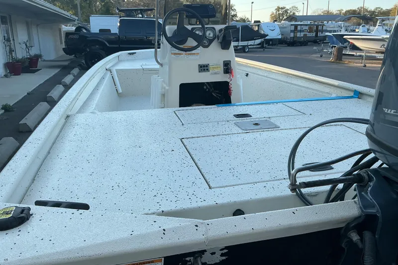 Slide: The Image of 2013 Xpress XP18CC boat with spacious deck and steering console in a marina setting. - 6