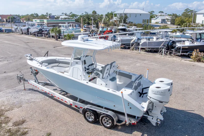 Slide: The Image of 2024 Cape Horn 24 XS boat on trailer with Suzuki engines, parked in a marina. - 13