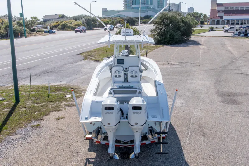 Slide: The Image of 2024 Cape Horn 24 XS boat with dual engines parked near a road. - 19