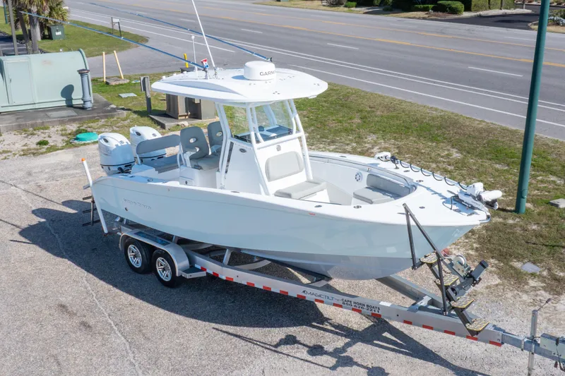 Slide: The Image of 2024 Cape Horn 24 XS boat on trailer, parked near a road. - 2