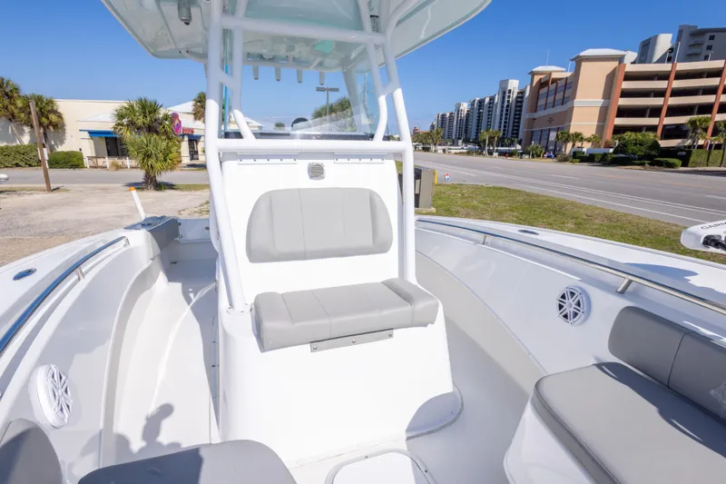 Slide: The Image of 2024 Cape Horn 24 XS boat interior with seating, parked near a road and buildings. - 26