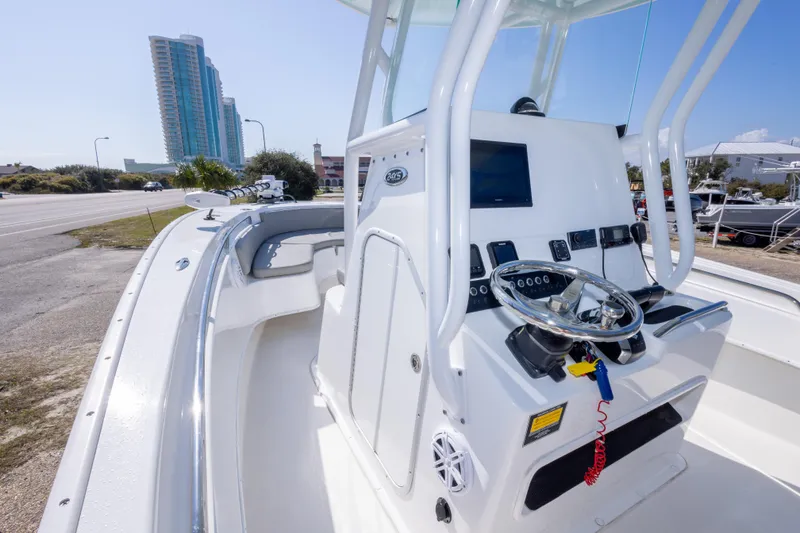 Slide: The Image of 2024 Cape Horn 24 XS boat console with steering wheel and controls, urban backdrop. - 30