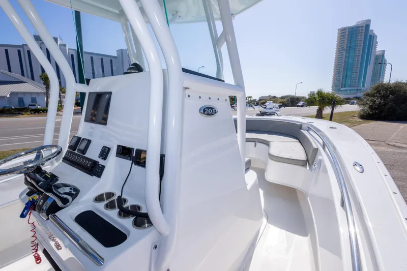 Slide: The Image of 2024 Cape Horn 24 XS boat interior with modern console and seating, near urban buildings. - 31