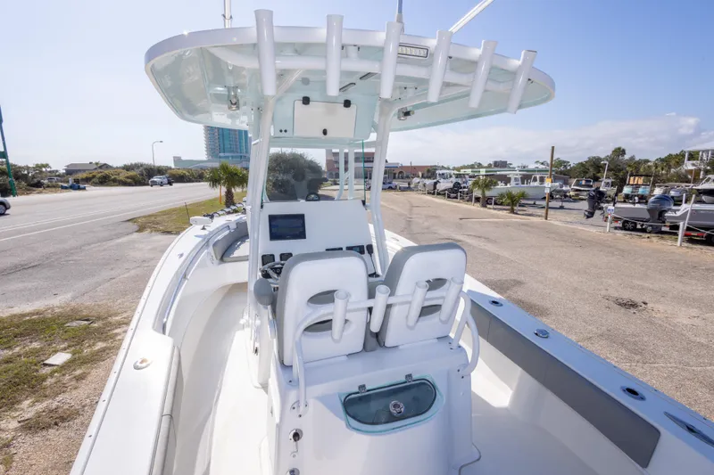 Slide: The Image of 2024 Cape Horn 24 XS boat with center console and seating, parked near a road. - 35