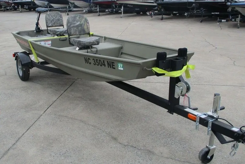 Slide: The Image of 2025 Tracker Grizzly 1436 Utility boat on trailer, featuring camo seats and registration number. - 3