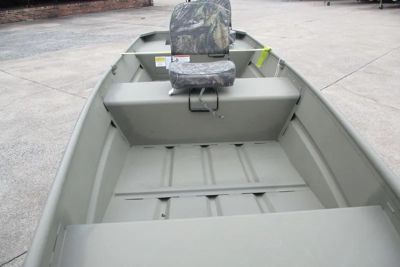 Slide: The Image of 2025 Tracker Grizzly 1436 Utility boat with camo seat, parked on concrete. - 5