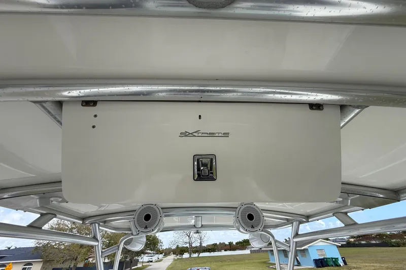 Slide: The Image of 2016 Extreme Boats XC 38 Express with speakers on deck, parked near residential area. - 131