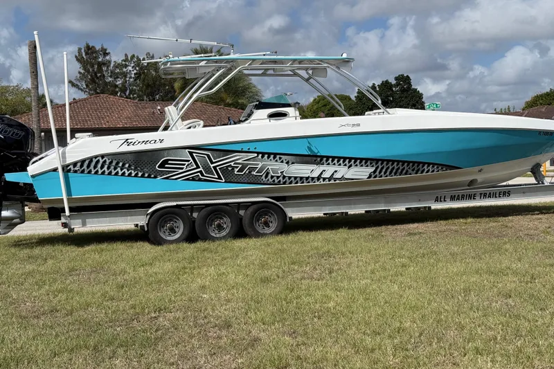 Slide: The Image of 2016 Extreme Boats XC 38 Express on trailer, vibrant blue and white design. - 31