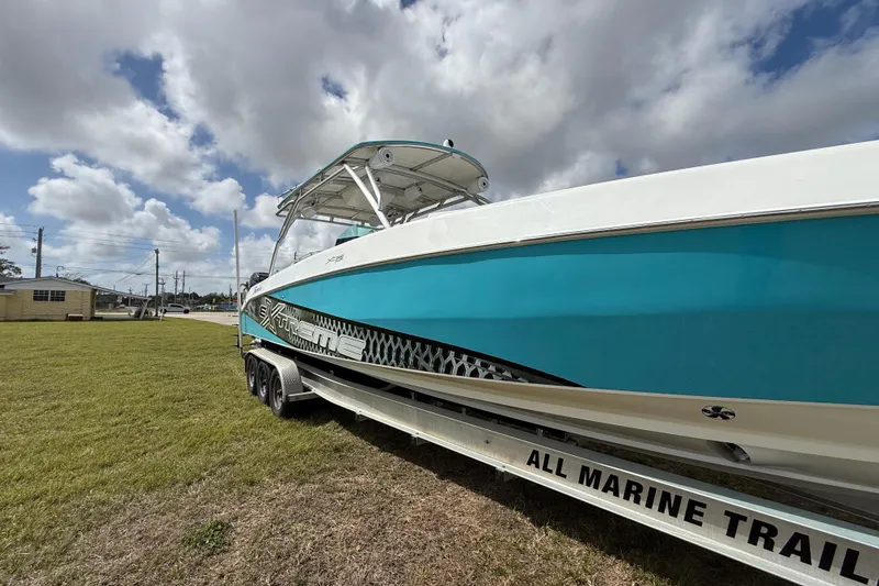 Slide: The Image of 2016 Extreme Boats XC 38 Express on trailer, vibrant blue hull, cloudy sky backdrop. - 39