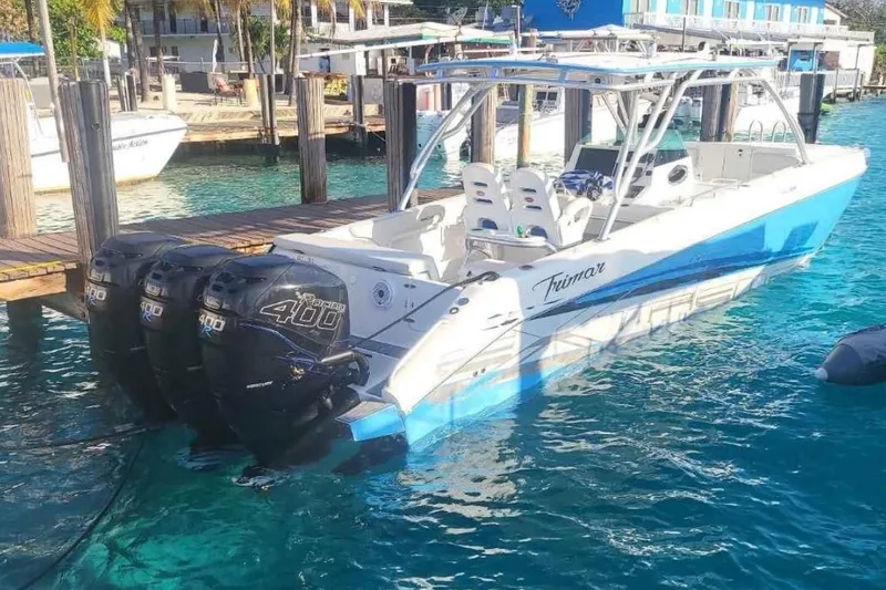 Slide: The Image of 2016 Extreme Boats XC 38 Express on trailer, triple outboard engines, parked on grass. - 4