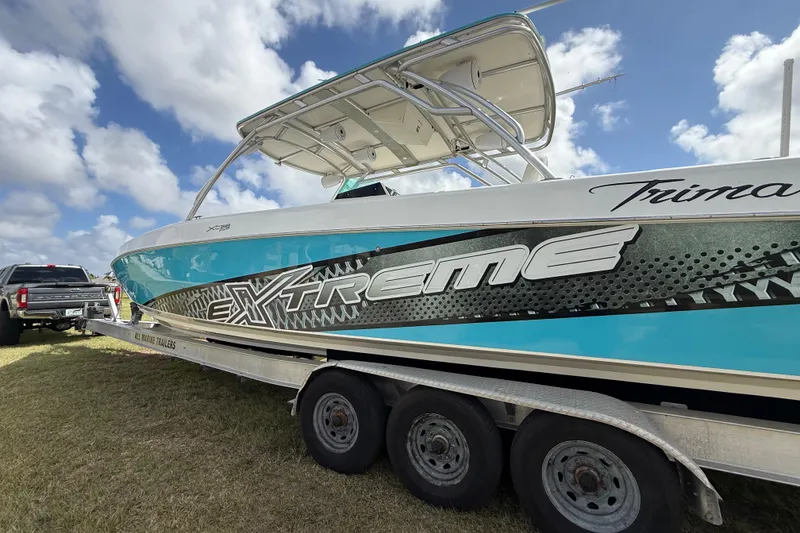 Slide: The Image of 2016 Extreme Boats XC 38 Express on trailer, vibrant design, clear sky background. - 56