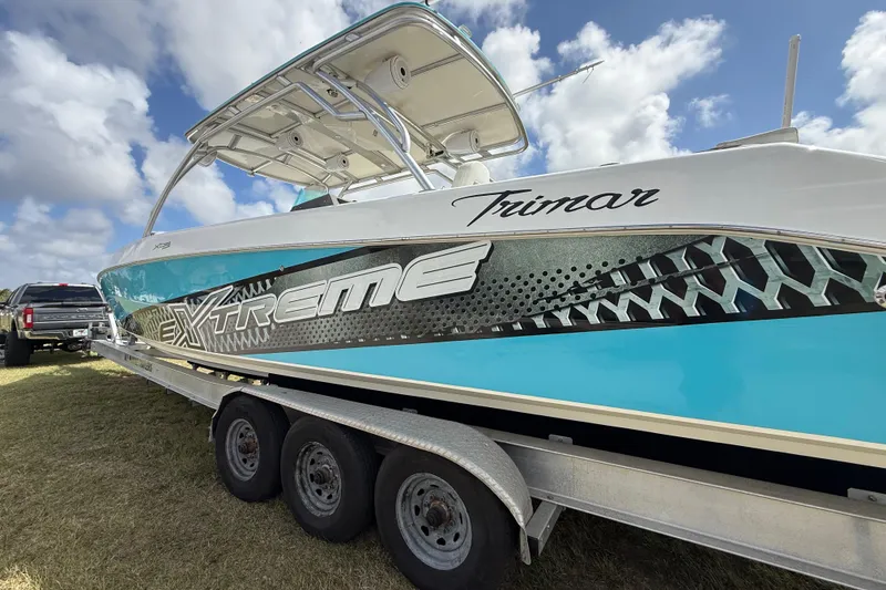 Slide: The Image of 2016 Extreme Boats XC 38 Express on trailer, vibrant design, under blue sky. - 57