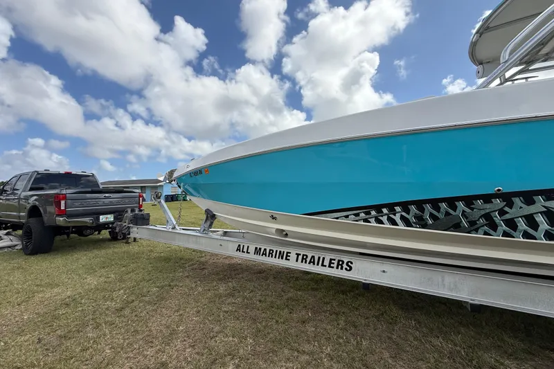 Slide: The Image of 2016 Extreme Boats XC 38 Express on trailer, parked beside a truck under a cloudy sky. - 58