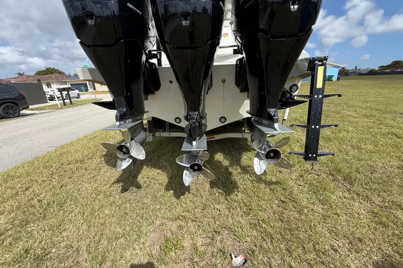 Slide: The Image of 2016 Extreme Boats XC 38 Express with triple outboard motors on grassy area. - 86