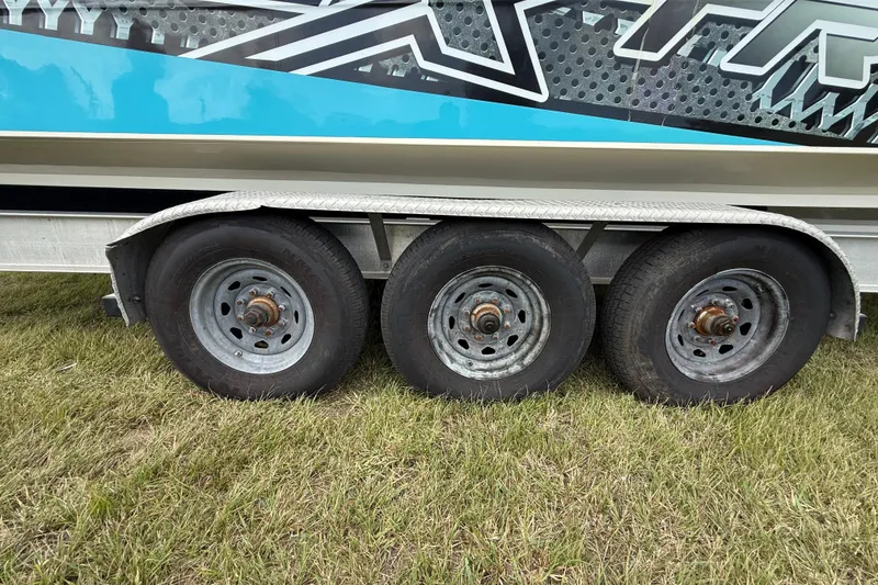 Slide: The Image of Trailer wheels of a 2016 Extreme Boats XC 38 Express on grass. - 89