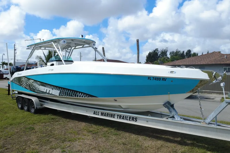 Slide: The Image of 2016 Extreme Boats XC 38 Express on trailer, vibrant blue and white design. - 9