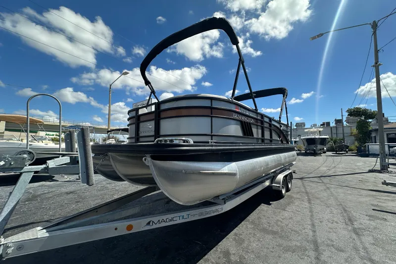 The Image of 2022 Bennington 22 L Quad Bench pontoon boat on trailer under blue sky. - 0