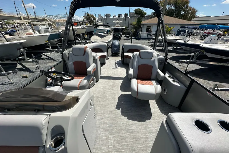 Slide: The Image of 2022 Bennington 22 L Quad Bench pontoon boat interior with luxurious seating and helm. - 13