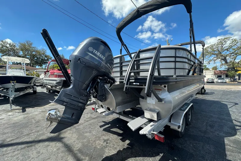 Slide: The Image of 2022 Bennington 22 L Quad Bench pontoon boat with Yamaha outboard motor on trailer. - 5