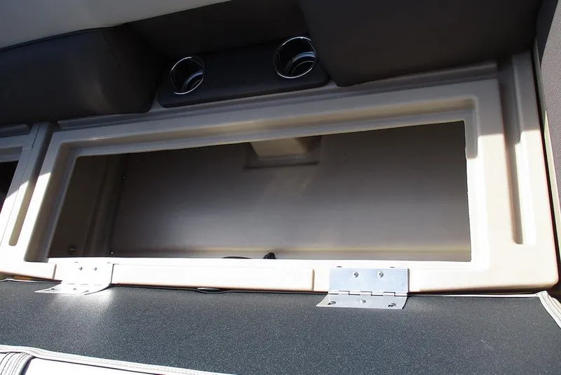 Slide: The Image of 2026 Bentley Pontoons Legacy 240 Cruise storage compartment with open lid and cup holders. - 17