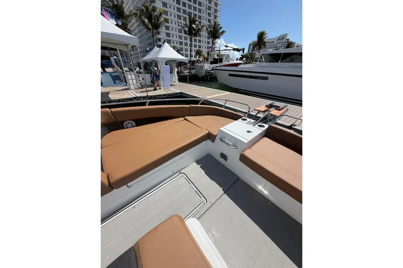 Slide: The Image of 2026 Jeanneau TH33 boat interior with tan seating at a marina. - 11
