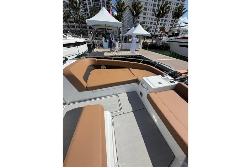 Slide: The Image of 2026 Jeanneau TH33 boat with tan seating, docked at a marina with palm trees. - 12