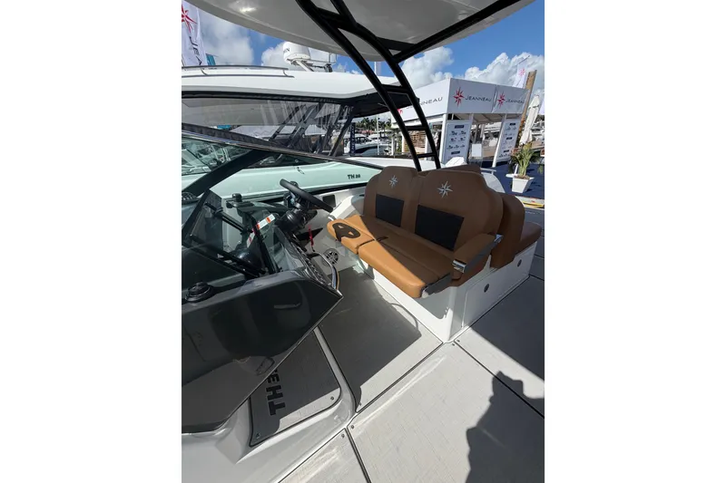 Slide: The Image of 2026 Jeanneau TH33 boat interior with brown seating and steering console. - 14