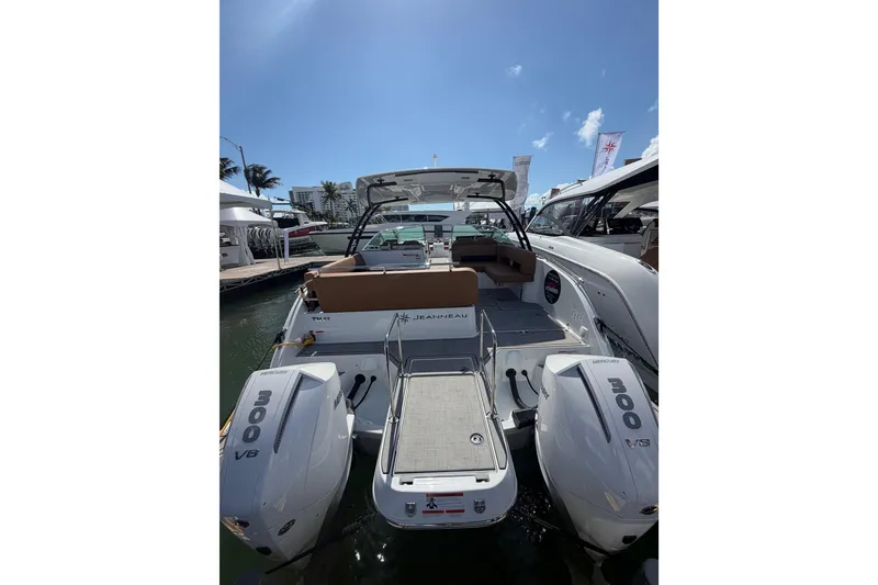 Slide: The Image of 2026 Jeanneau TH33 boat with twin 300 HP engines docked under clear blue sky. - 3