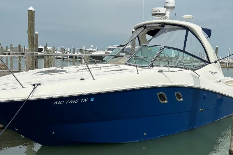 The Image of 2008 Sea Ray Sundancer 310 docked at marina, featuring sleek blue and white design. - 0
