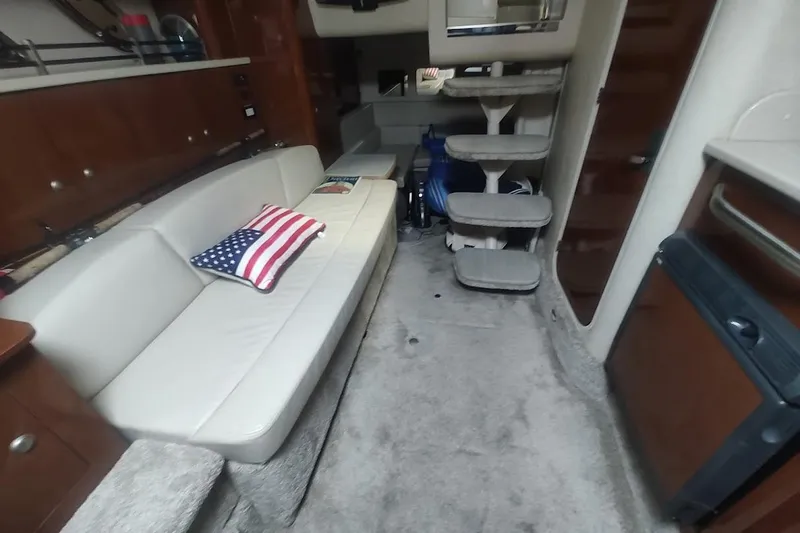 Slide: The Image of Interior of 2008 Sea Ray Sundancer 310 with sofa, American flag pillow, and carpeted steps. - 12