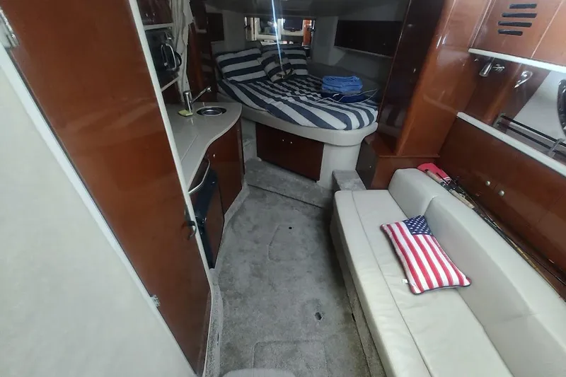 Slide: The Image of Interior of 2008 Sea Ray Sundancer 310 with cozy seating and striped bedding. - 16