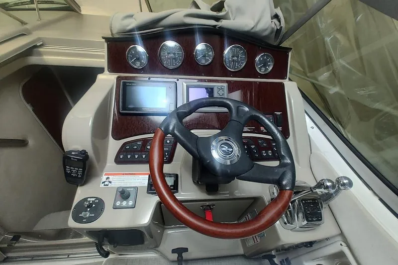 Slide: The Image of 2008 Sea Ray Sundancer 310 helm with steering wheel, gauges, and navigation controls. - 20