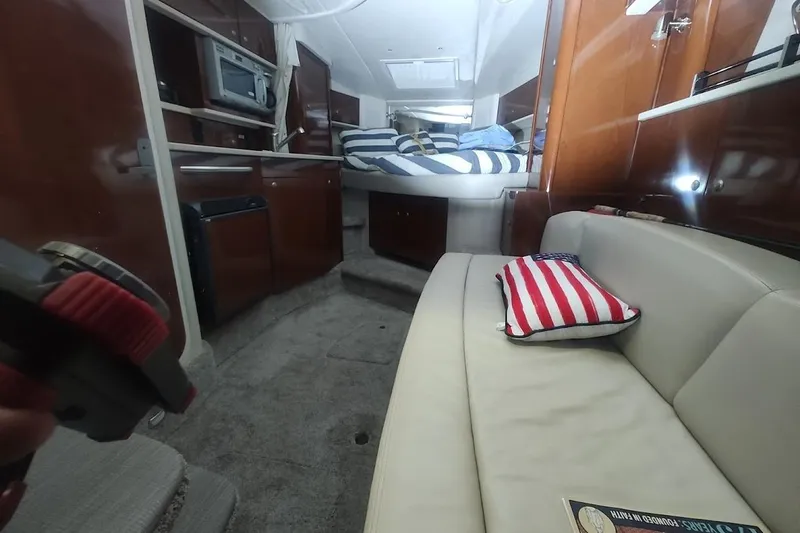 Slide: The Image of Interior of 2008 Sea Ray Sundancer 310 with cozy seating and striped bedding. - 8