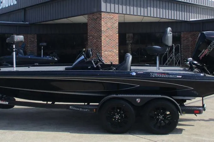 Slide: The Image of 2025 Triton 20XP boat, sleek black design, parked outside a building. - 12