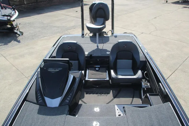 Slide: The Image of 2025 Triton 20XP boat interior with seating and dashboard, parked on concrete. - 13