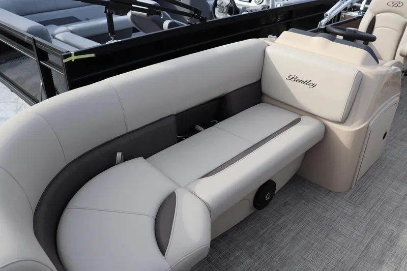 Slide: The Image of 2026 Bentley Pontoons LE 180 Cruise interior with beige seating and steering console. - 2