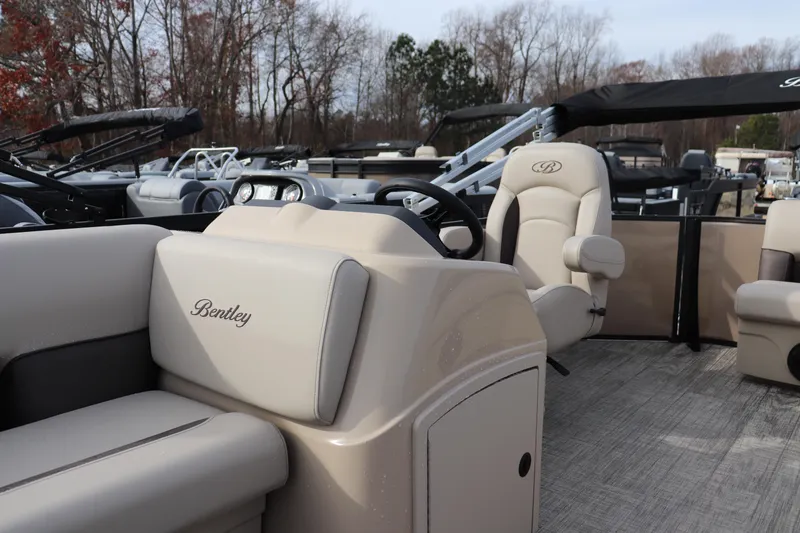 Slide: The Image of 2026 Bentley Pontoons LE 180 Cruise interior with beige seating and steering wheel. - 4
